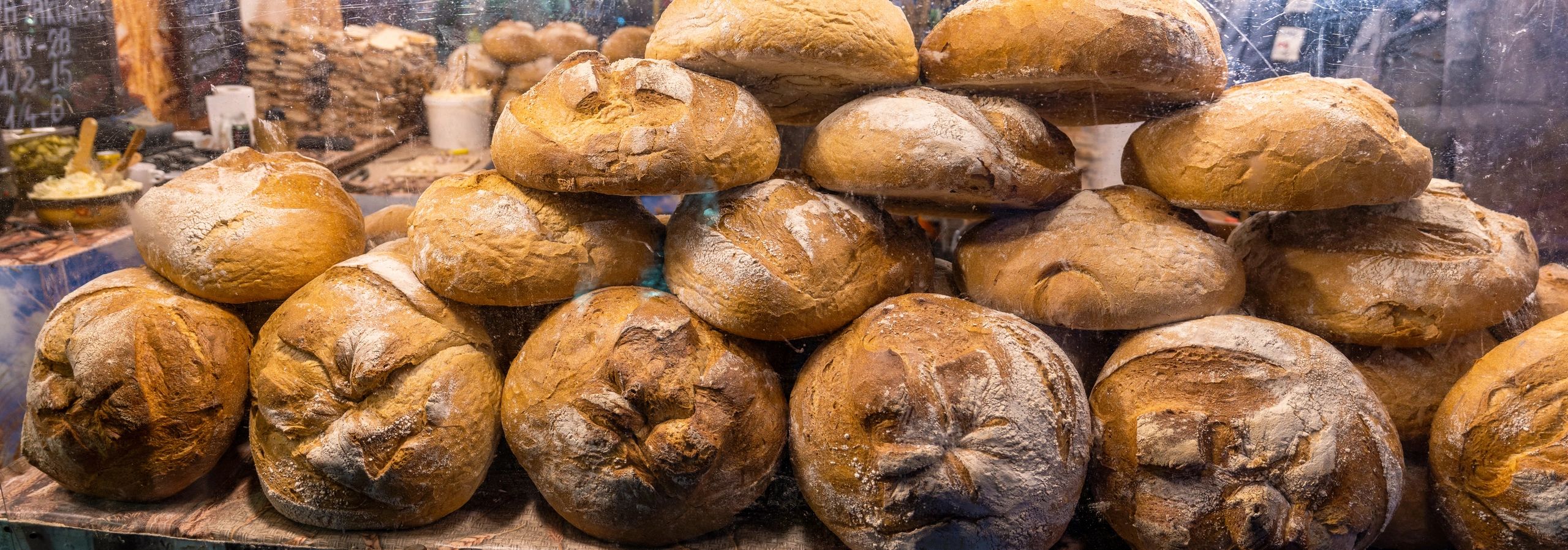 Fresh artisan bread loaves stacked in a warm bakery setting