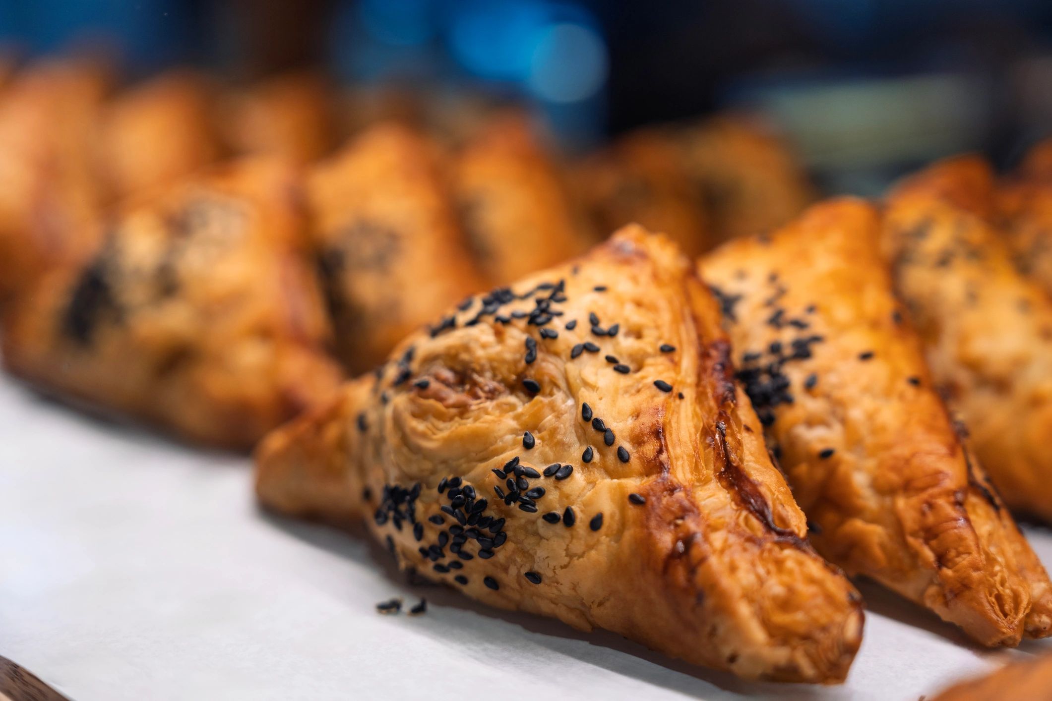 Golden puff pastries topped with black sesame seeds