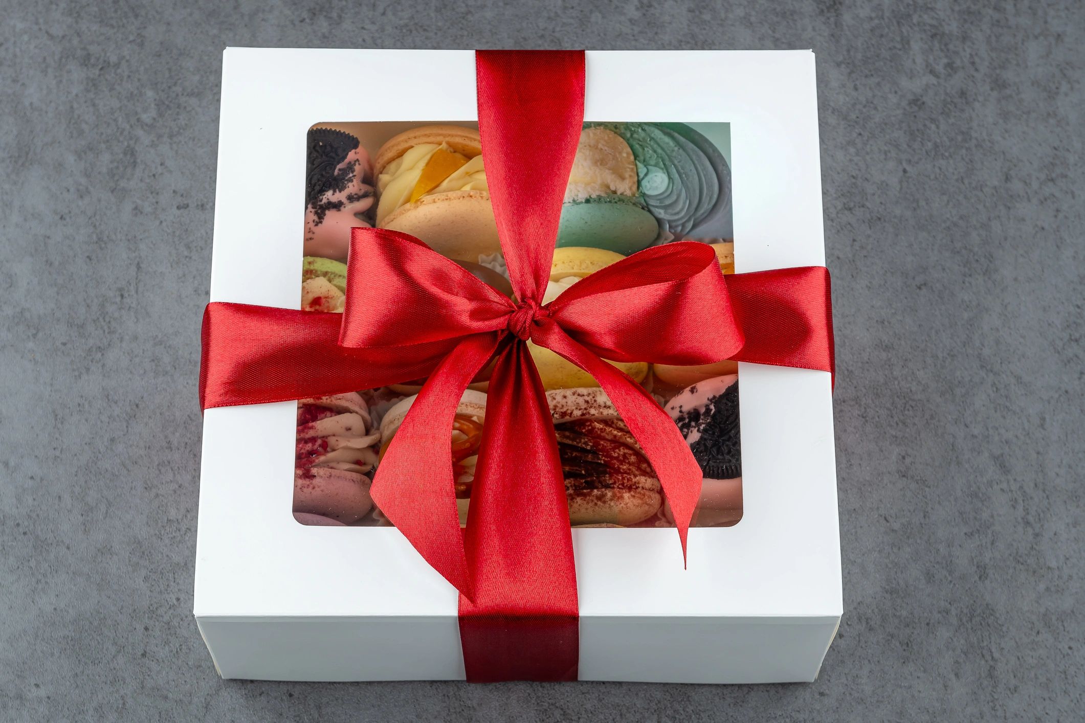 Gift box of assorted macarons tied with a red ribbon