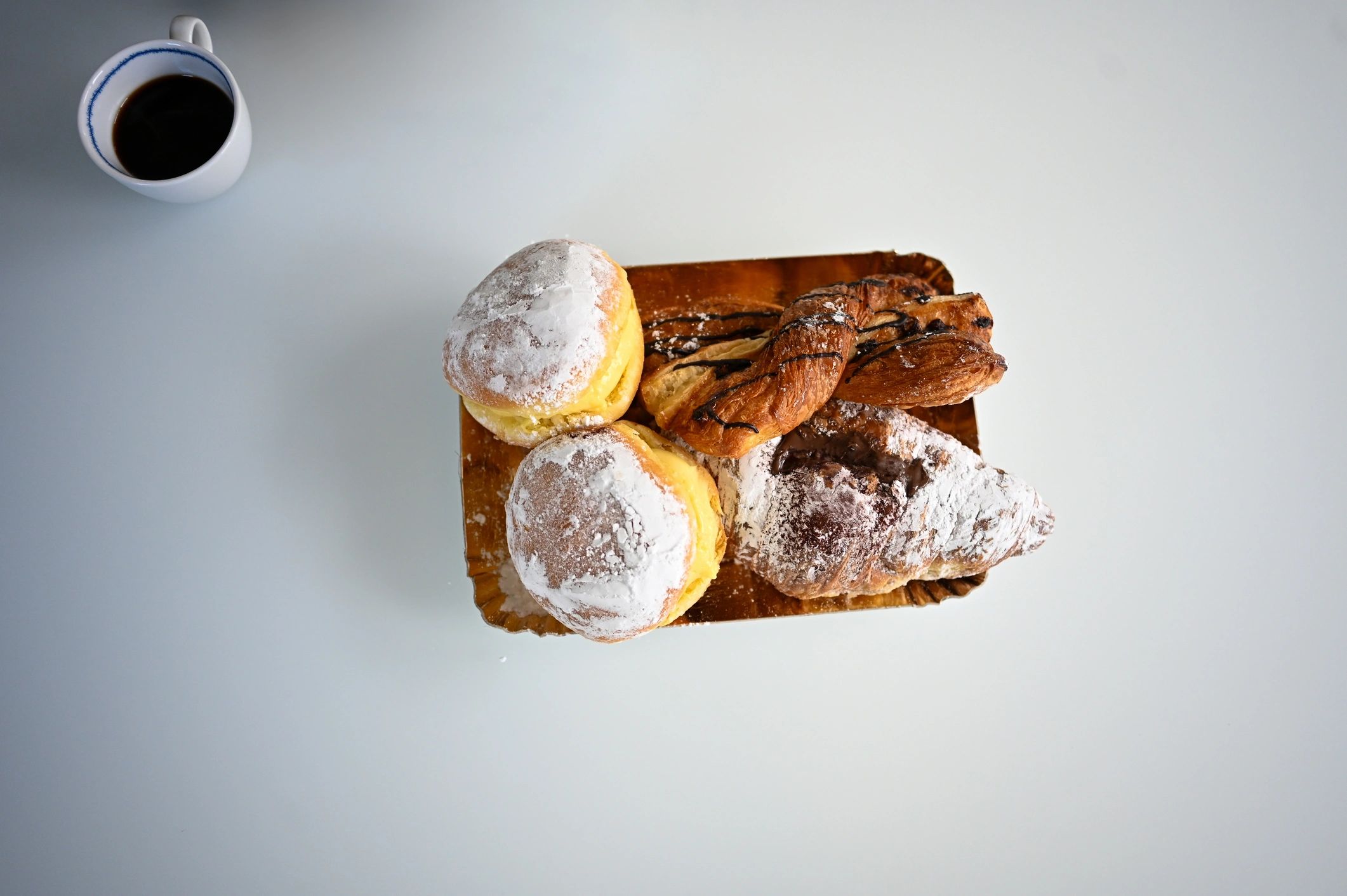 Coffee with assorted pastries on a white table